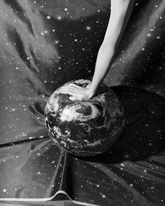 Image: Diana Sosnowska. an arm and hand pushing down on an inflatable earth